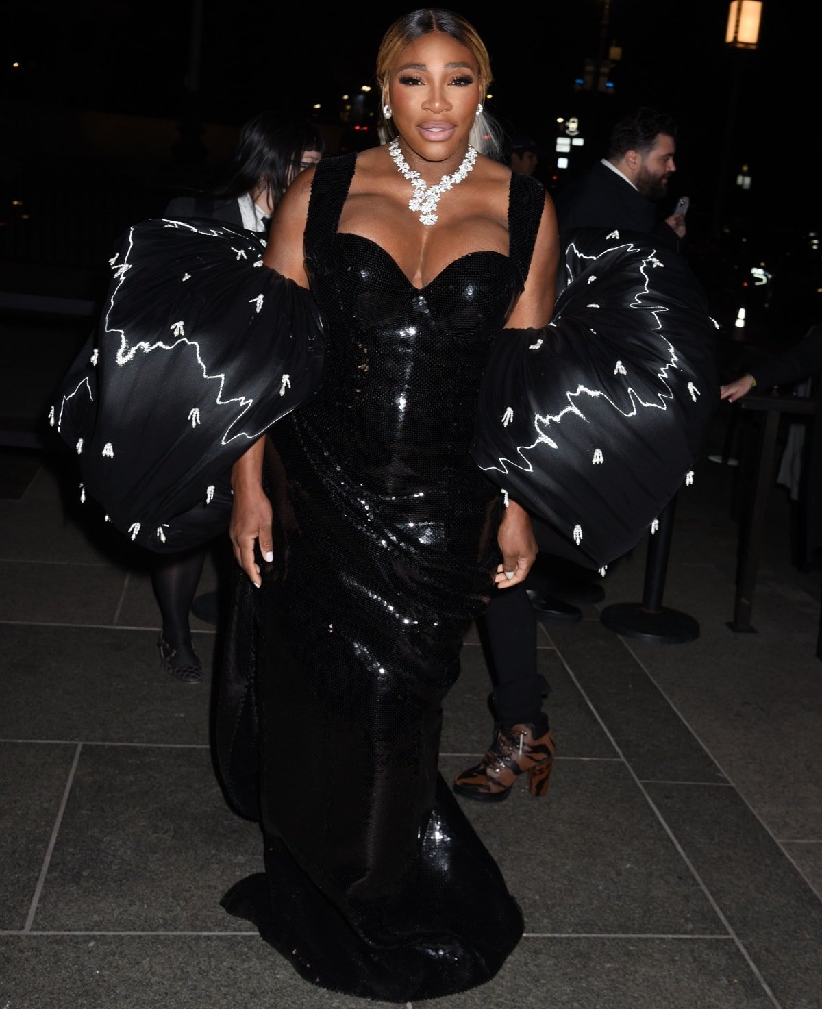 Serena Williams wearing a custom look from Thom Browne featuring statement-making puff sleeves, sequin and crystal embellishments, and a dramatic train