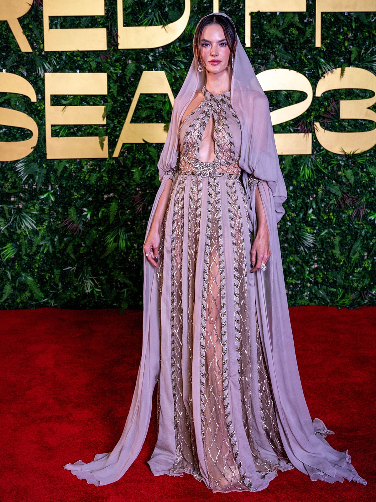Alessandra Ambrosio is keeping the hooded gown hype train going by donning a sheer cutout gown by Elie Saab at the Red Sea Film Festival 2023