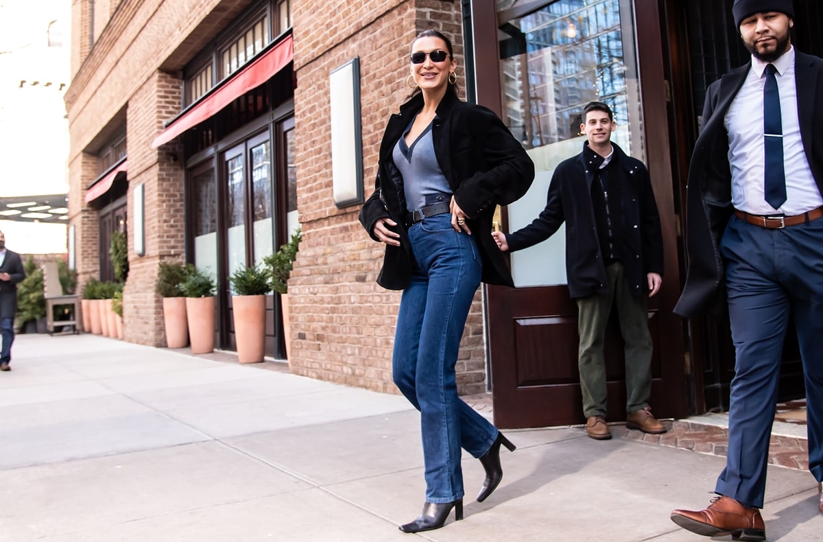 Bella Hadid steps out in New York City, bringing back the 90s business casual look with a modern twist, sporting high-waisted navy jeans and a corduroy black blazer