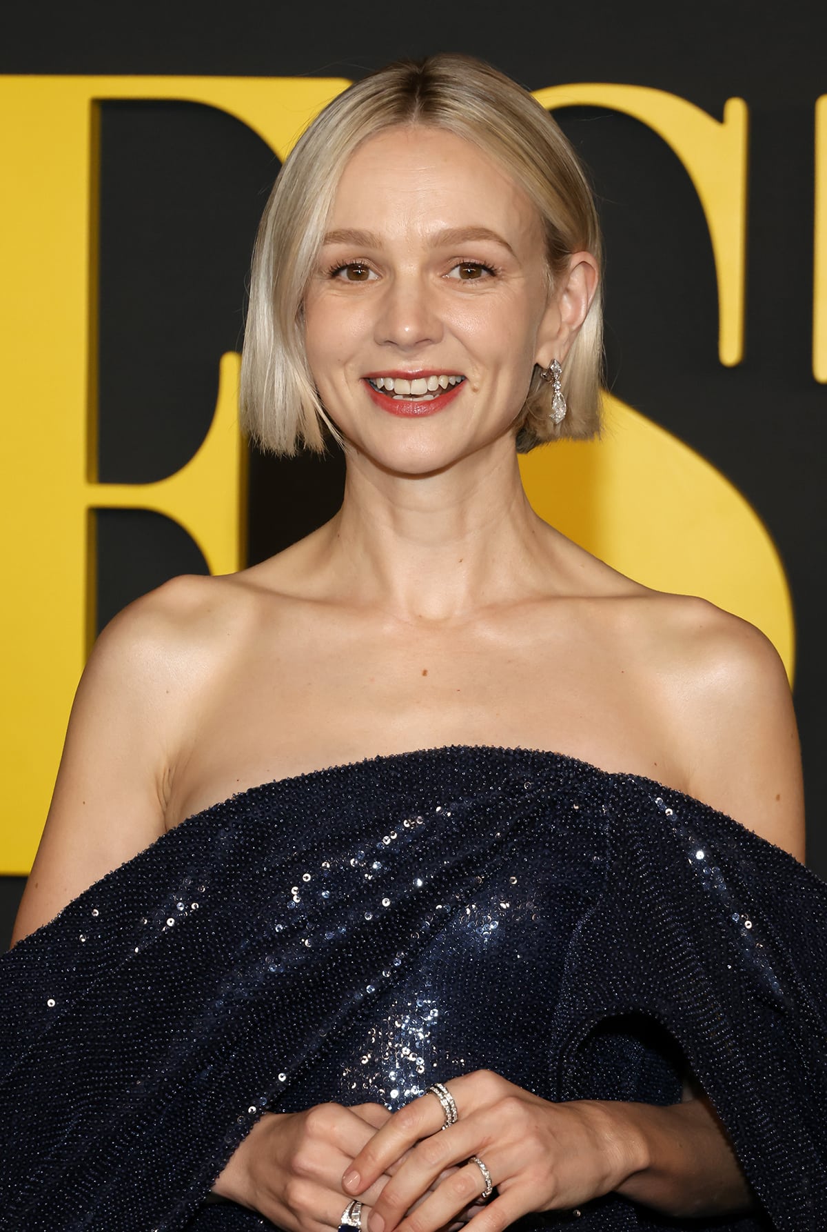 Carey Mulligan sports her signature short bob hairstyle and highlights her lovely facial features with soft pink makeup and lipstick