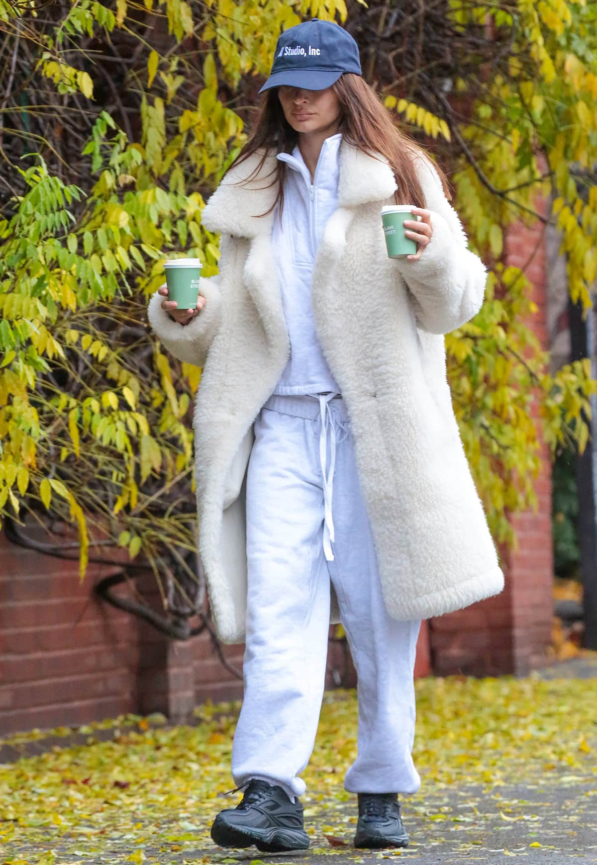 Emily Ratajkowski embraces winter athleisure in a white sweatsuit by Four Three Seven layered under an ivory fleece coat on December 11, 2023