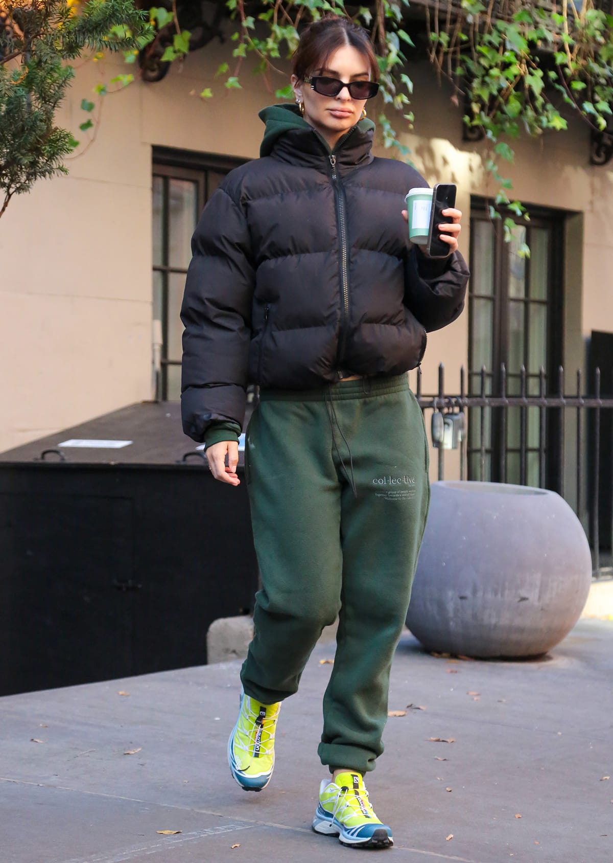 Emily Ratajkowski looks cozy in a black Thirty Years Ultra Puff winter jacket and green Helfrich Collective hoodie and sweatpants while on a coffee run in New York City on December 13, 2023