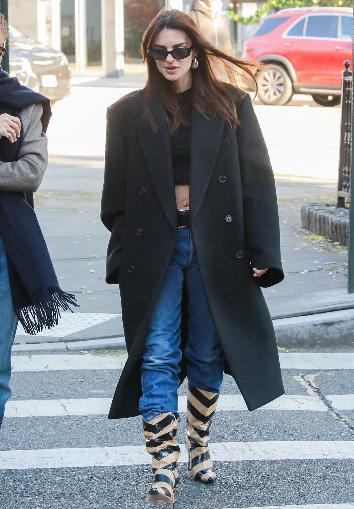Emily Ratajkowski nails sophisticated winter dressing in a black Cotton On crop top, blue jeans, and black Wardrobe.NYC coat on December 12, 2023