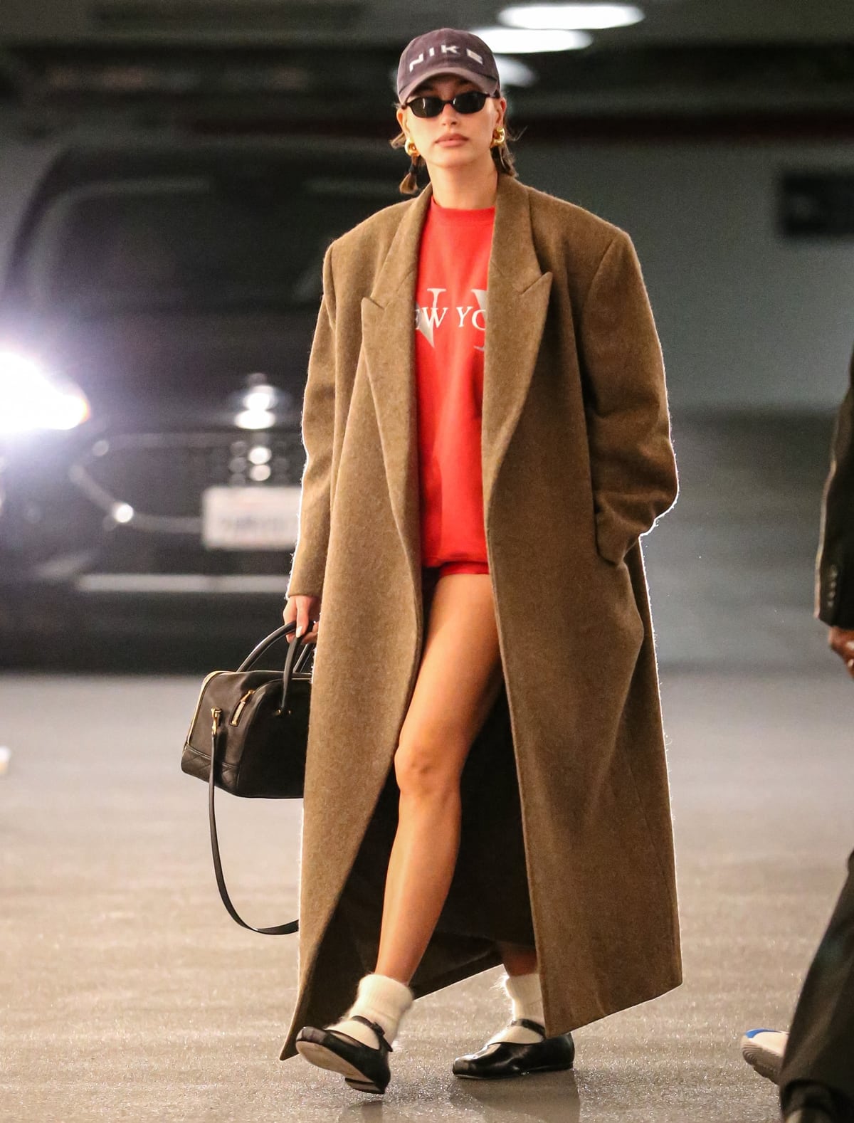 Hailey Bieber makes a bold statement in Beverly Hills with her vibrant red New York sweatshirt paired with ultra-short bicycle shorts, highlighting her toned legs