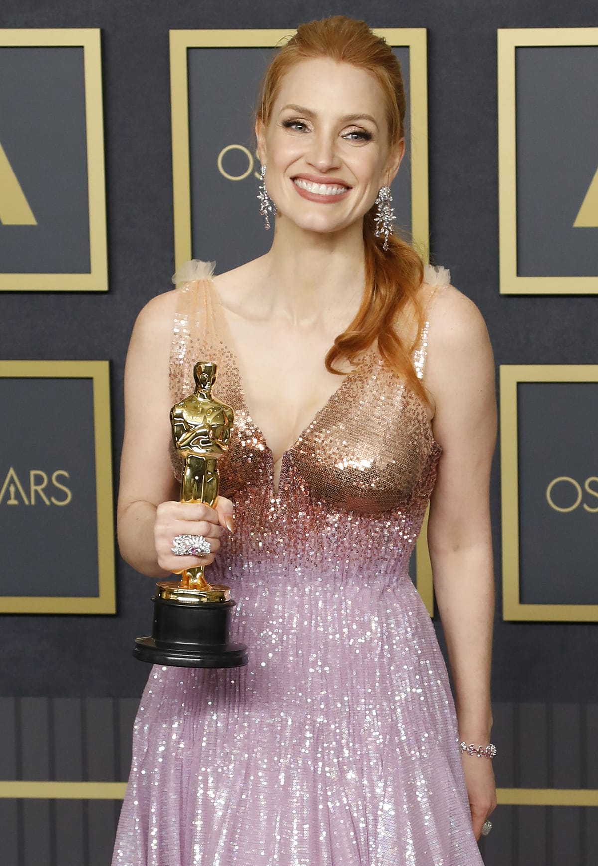 Jessica Chastain shows off her Oscar for Best Actress trophy while clad in a custom Gucci gown at the 94th Academy Awards on March 27, 2022