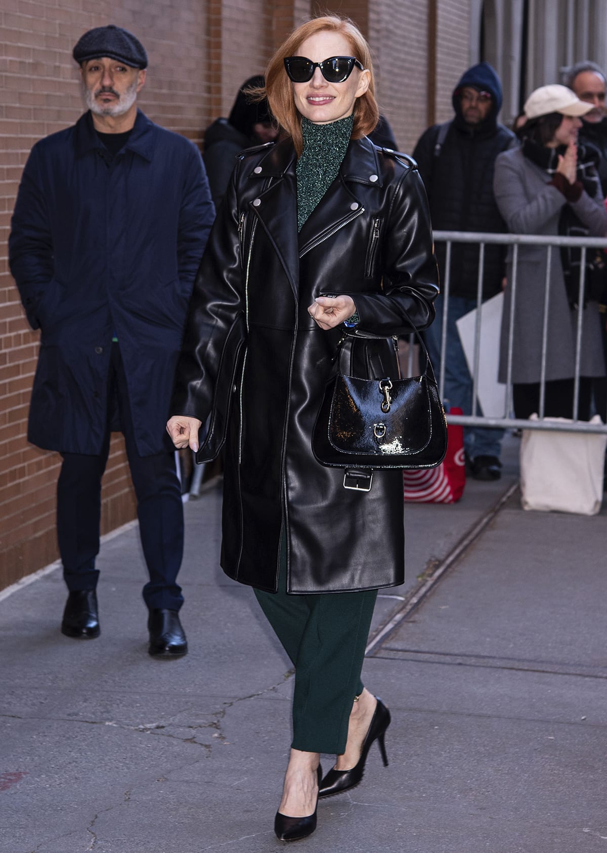 Jessica Chastain wraps herself warm in a black leather moto coat layered over her green outfit
