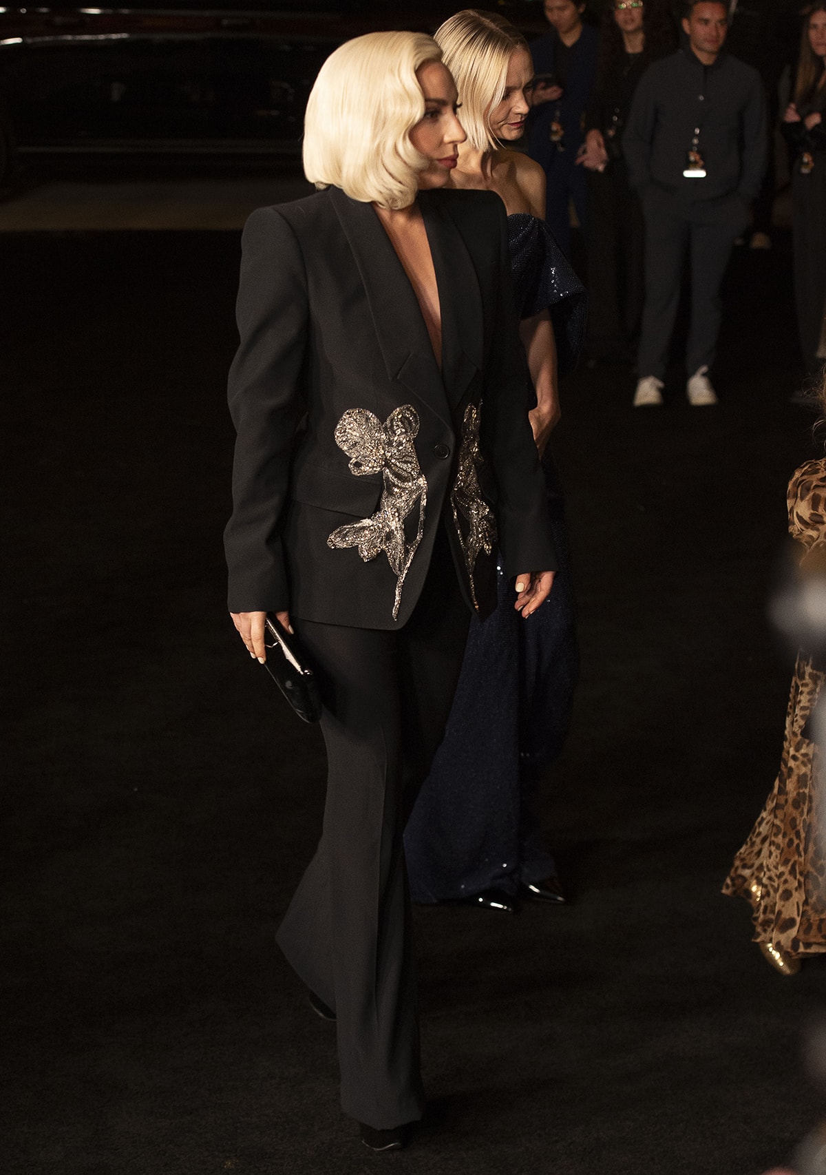 Lady Gaga embraces a shirtless blazer look in a black Alexander McQueen orchid crystal-embroidered blazer and slightly flared wool pants