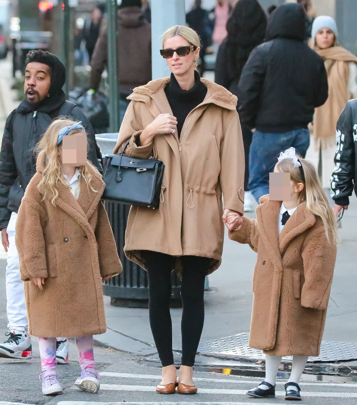 Nicky Hilton Rothschild, epitomizing urban elegance, walks through New York City with her daughters, Lily and Teddy, on December 12, 2023