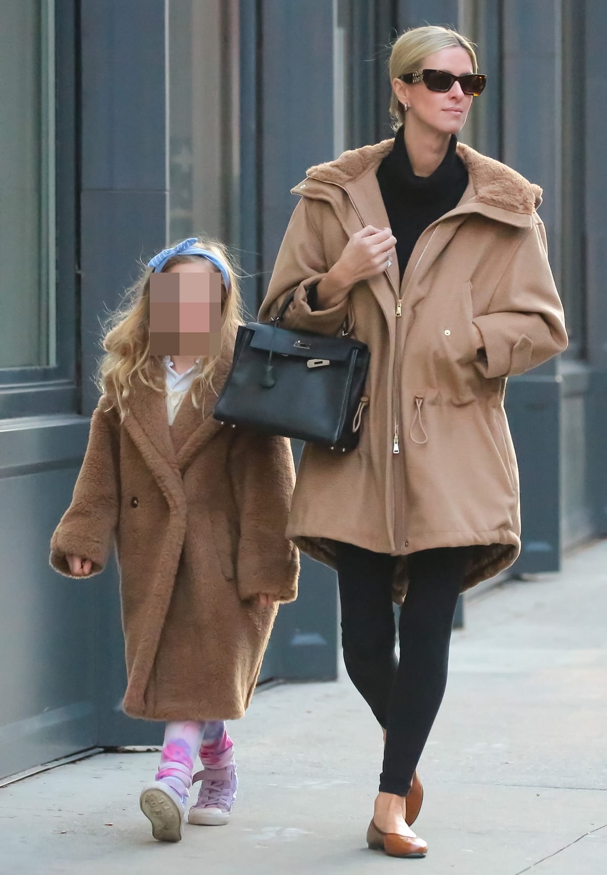 Clad in a sophisticated black and tan ensemble, Nicky Hilton Rothschild's winter style blends chic comfort with her signature fashion flair, as she navigates the city's vibrant streets
