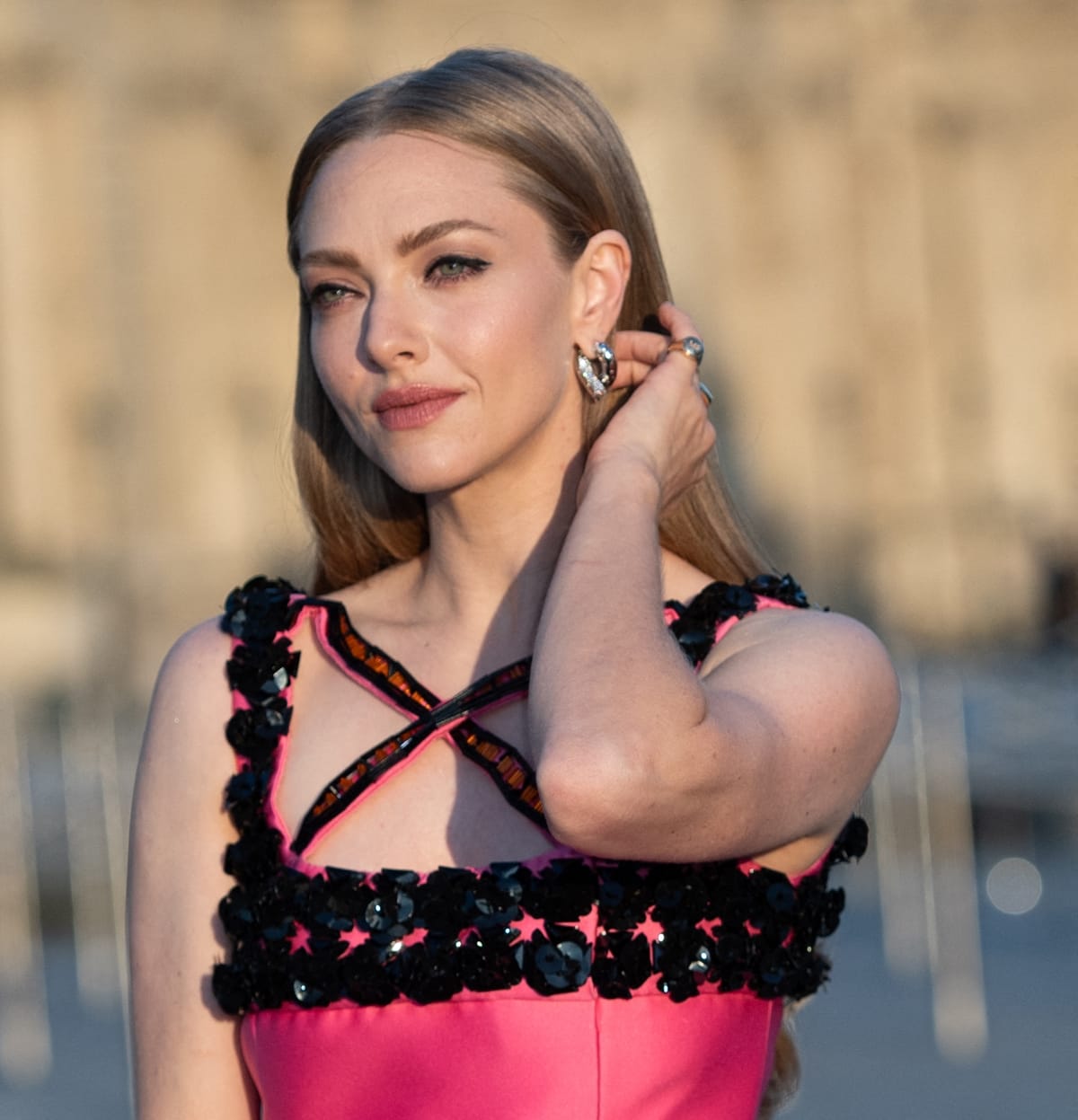 Adorned with Tabayer's Oera hoop earrings and diamond ring, Amanda Seyfried complements her vibrant Prada gown with sophisticated jewelry choices at the Lancome X Louvre photocall as part of Paris Fashion Week on September 26, 2023 in Paris, France
