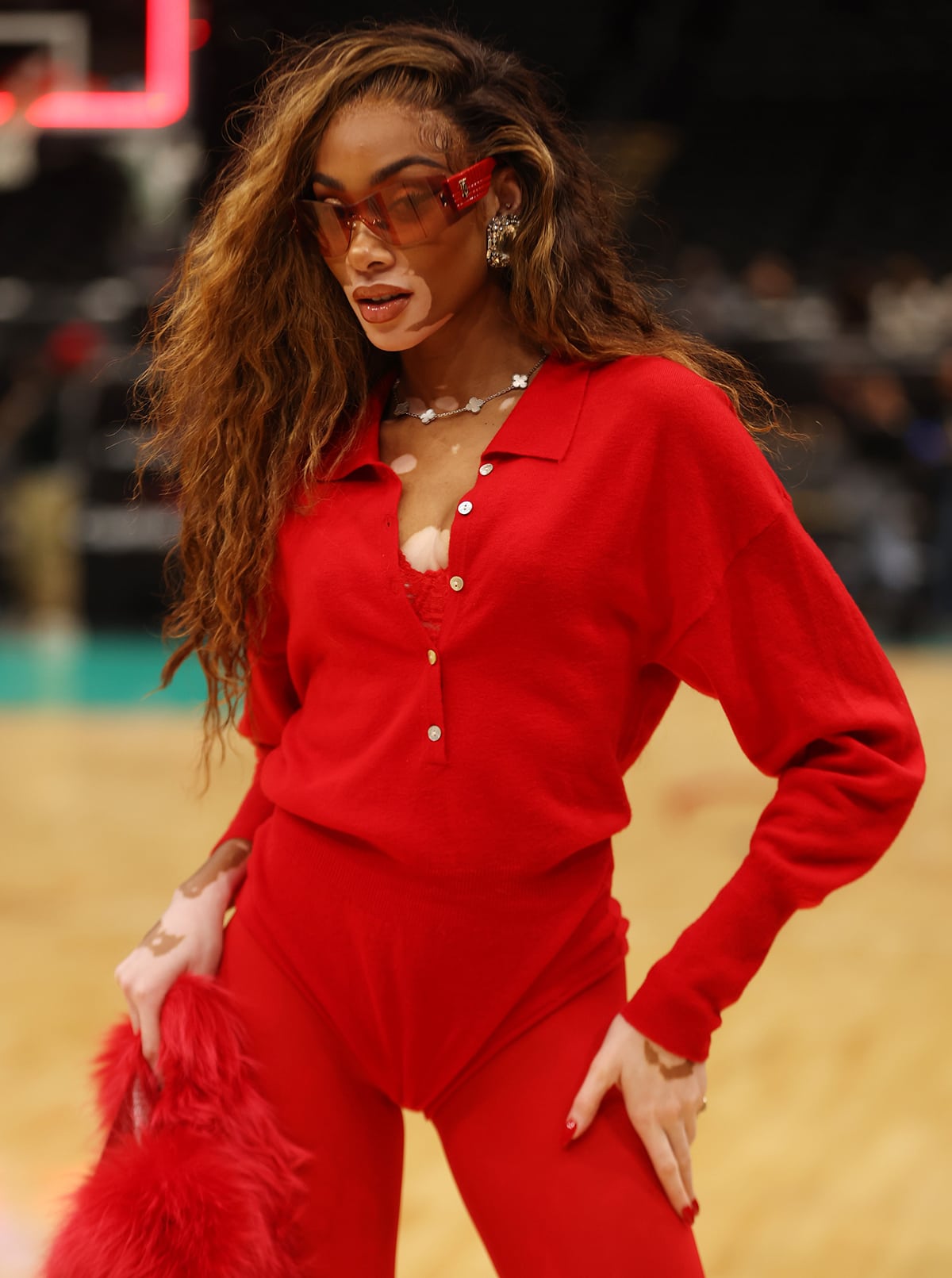 Winnie Harlow styles her all-red look with chunky diamond-embellished earrings and a Van Cleef & Arpels Alhambra necklace with white mother-of-pearl