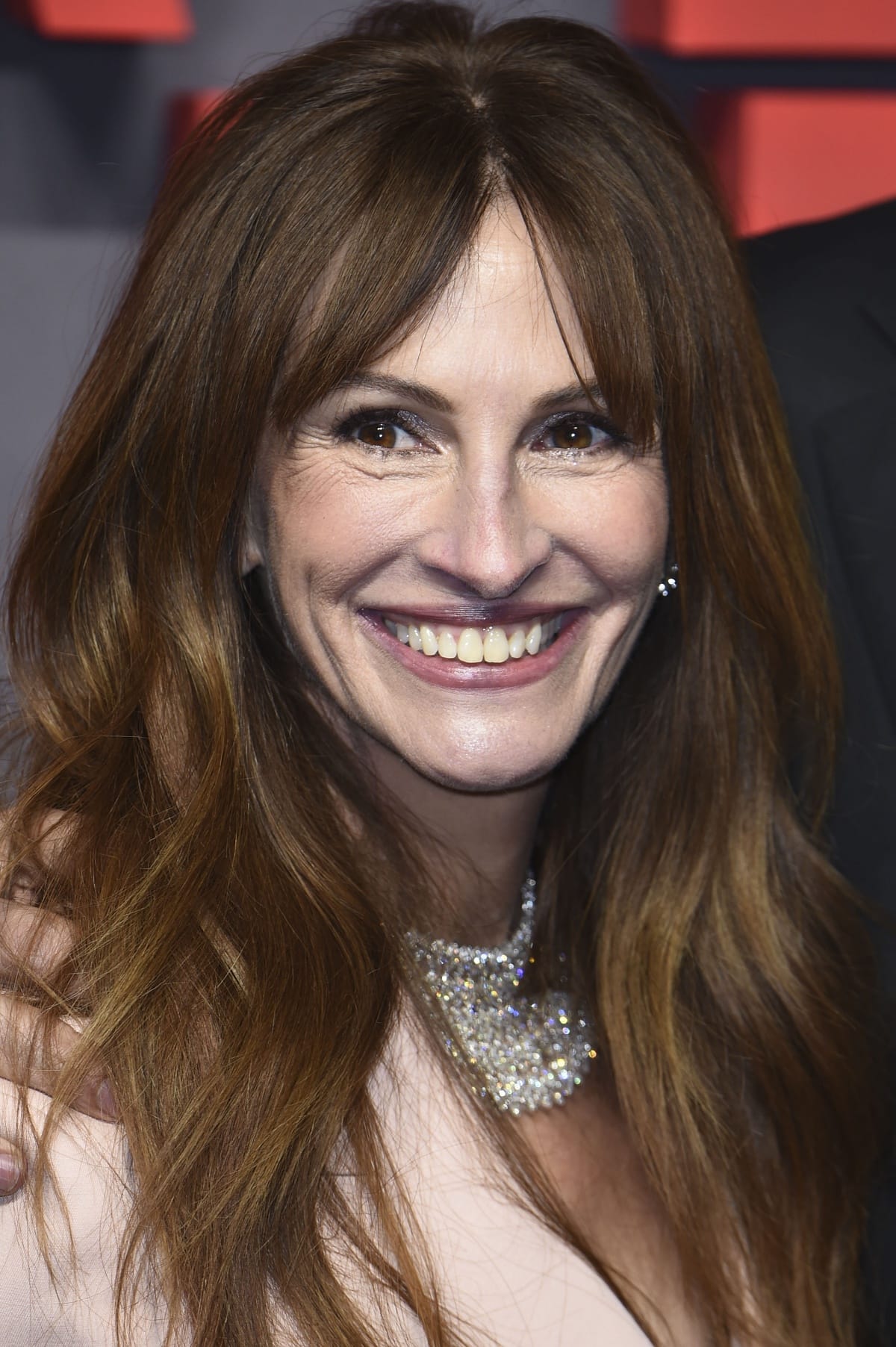 Julia Roberts’ beauty look consisted of a rose-colored lip, Chopard jewelry, and new red hair styled in soft waves with bangs