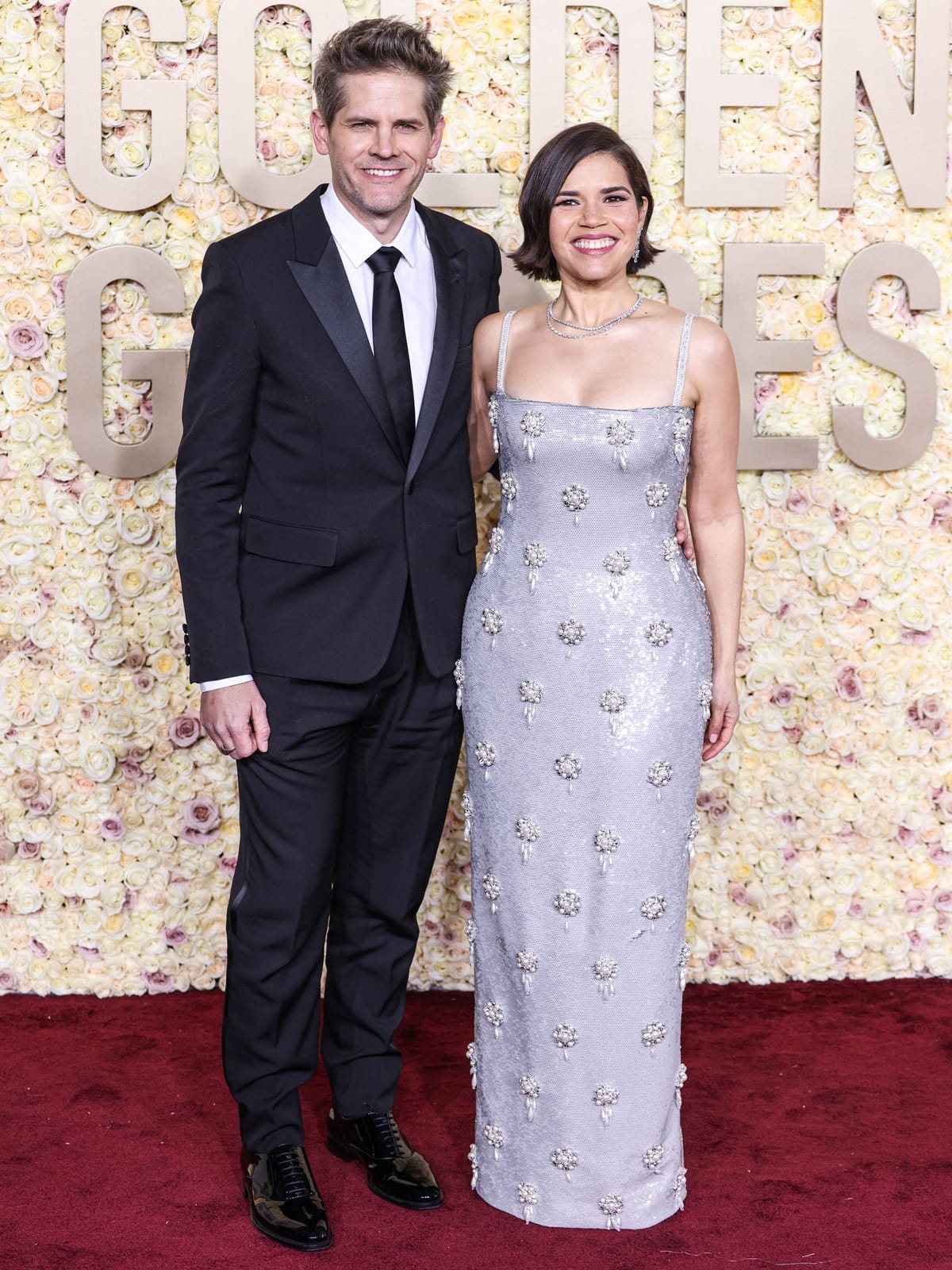 At the 81st Golden Globe Awards in Beverly Hills, America Ferrera, accompanied by her husband Ryan Piers Williams, radiates glamour in a form-fitting silver gown from Dolce & Gabbana