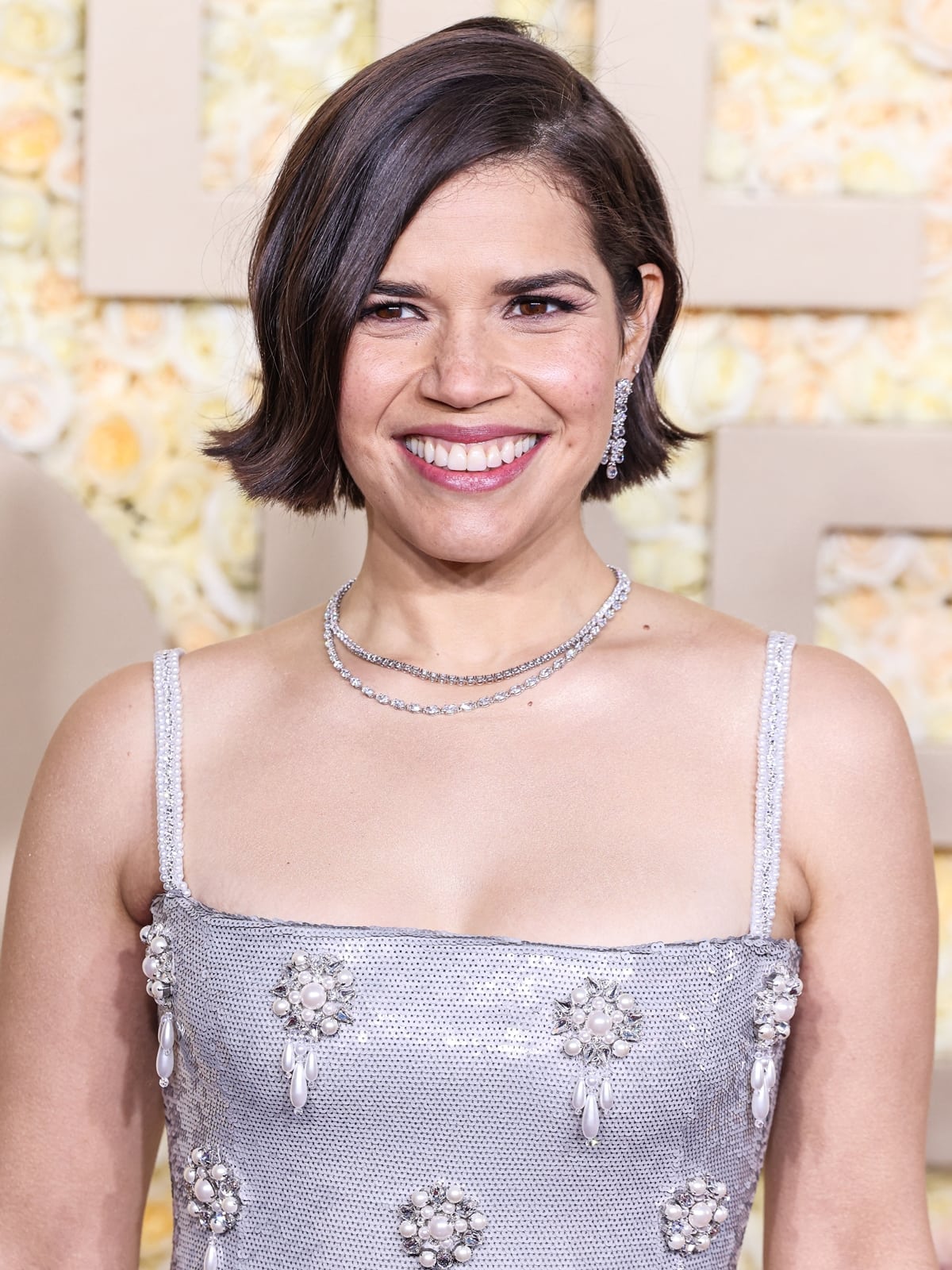 Ferrera's ensemble is complemented by a two-strand white diamond necklace and silver rhinestone earrings from Harry Winston, while her makeup and side-parted wavy hairstyle add a touch of classic elegance