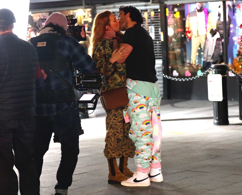 Blake Lively, on the set of 'It Ends With Us,' sporting an eccentric camouflage ensemble mixing three camo prints, including a button-up shirt and an oversized jacket, complete with 1960s Beo-Gam camo pants and beige Chelsea boots