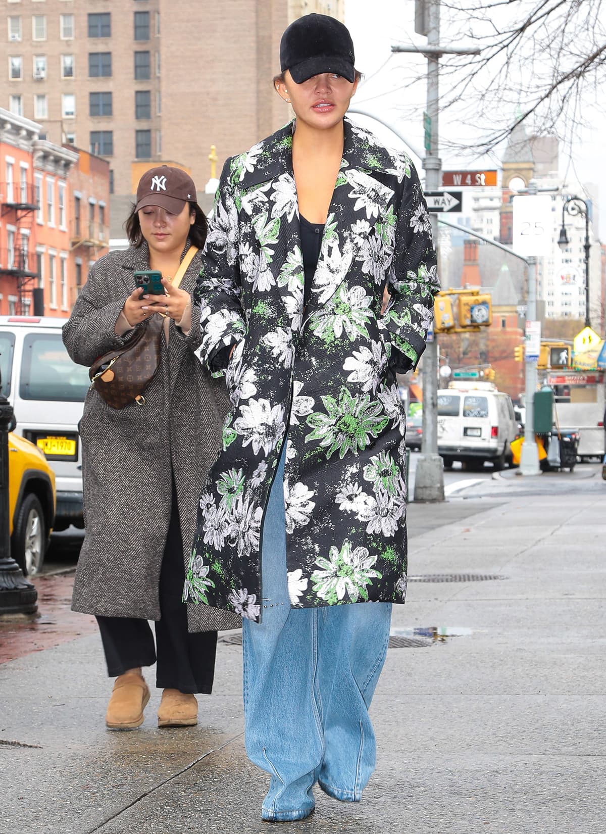 Chrissy Teigen enjoys her Chrissy & Dave Dine Out press tour break in a black cropped sweater, baggy jeans, and floral Stine Goya floral coat in New York City on January 25, 2024