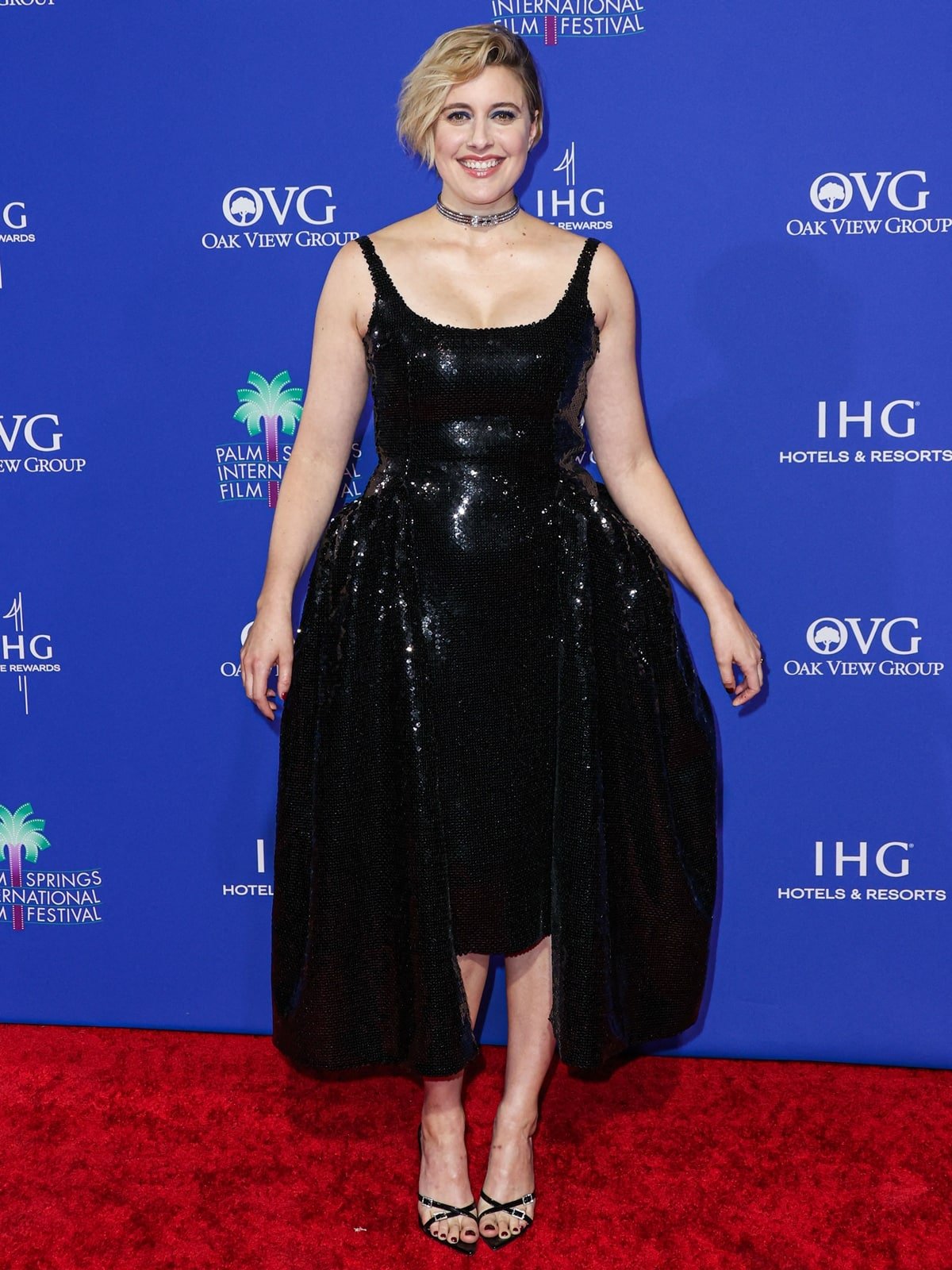 Elegance Personified: Greta Gerwig radiates on the red carpet in her custom 16Arlington black sequined dress at the 2024 Palm Springs International Film Festival Film Awards at Palm Springs Convention Center on January 4, 2024 in Palm Springs, California