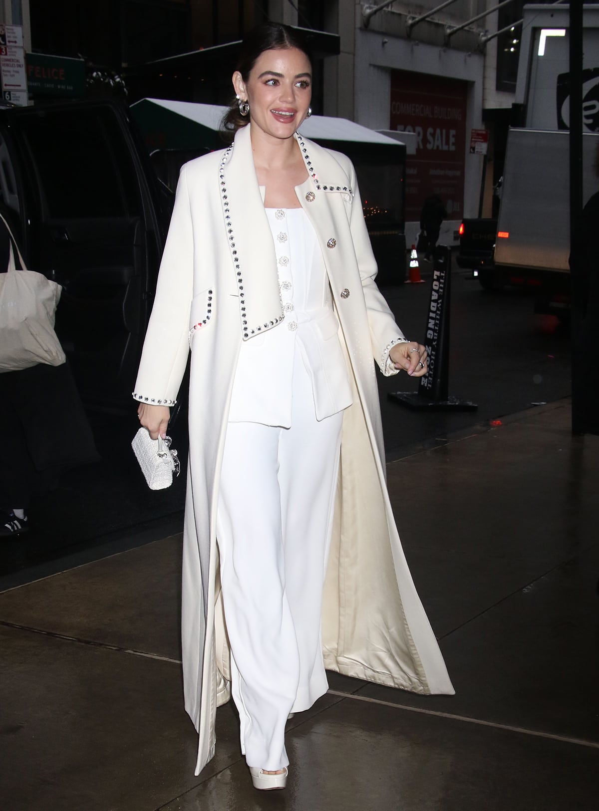 Lucy Hale layers her strapless jumpsuit underneath a vintage white Marc Jacobs coat
