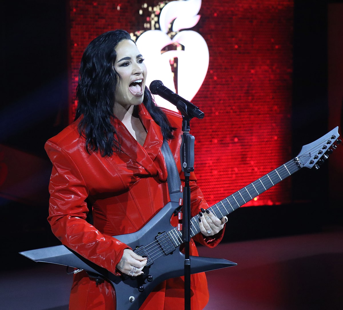 Demi Lovato swaps her red ballgown for a red latex pantsuit for her 10-song set