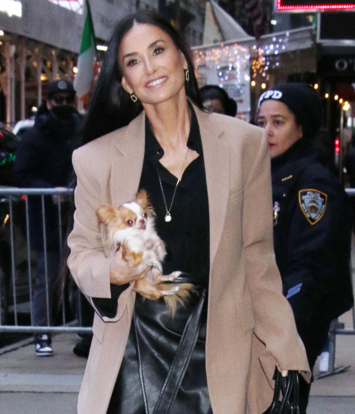 Demi Moore styles her look with Shy Creation earrings and a long pendant necklace while cradling her Chihuahua dog, Pilaf