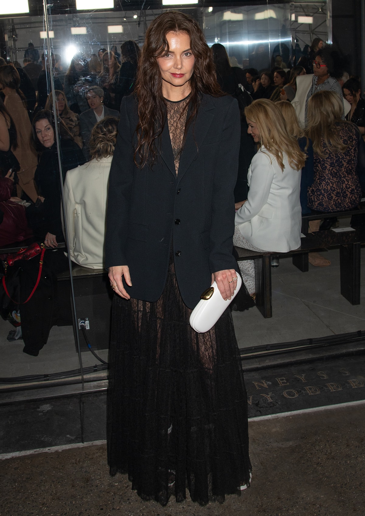Katie Holmes shows a hint of skin in a Chantilly lace bodysuit and a matching maxi skirt with an oversized blazer at Michael Kors' Fall/Winter 2024 show during New York Fashion Week