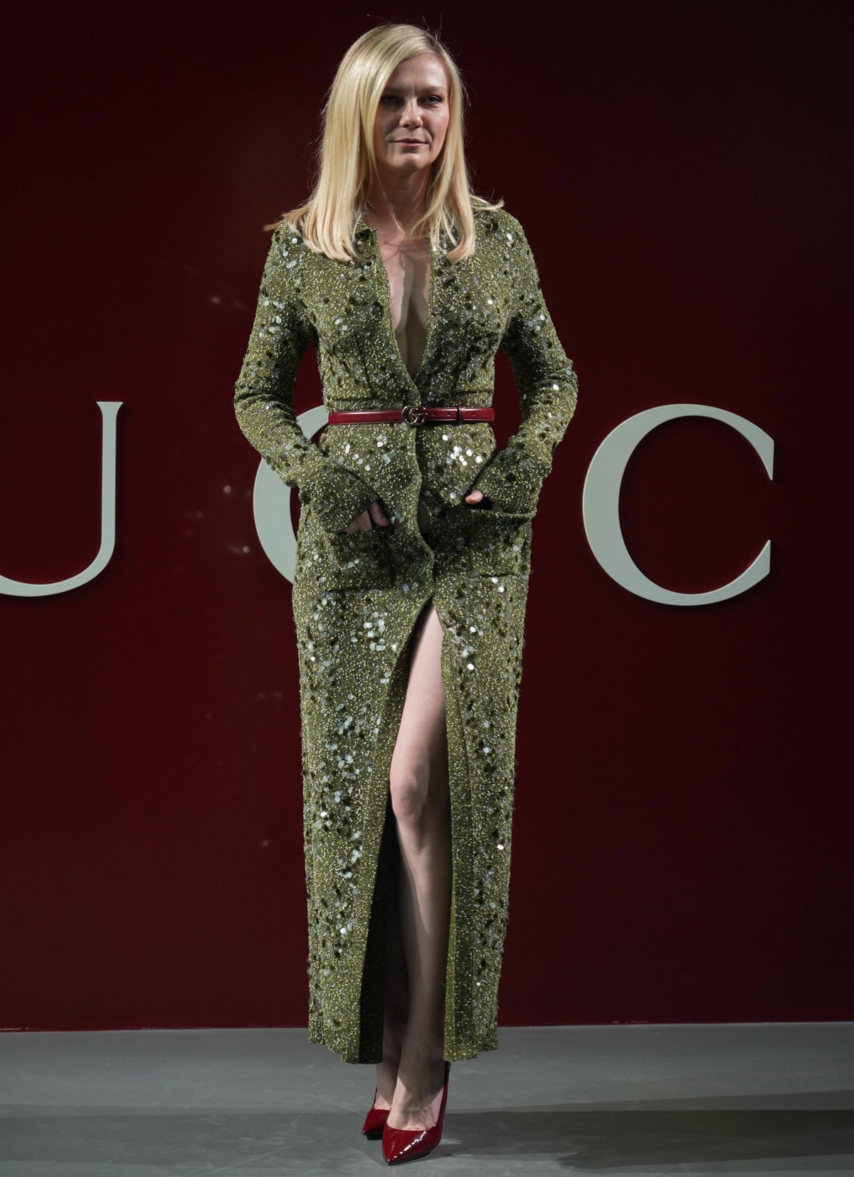 Kirsten Dunst's long-sleeved masterpiece shimmers with layers of silver and black sequins, featuring a plunging neckline and a daring thigh-high slit, revealing a bold twist to the ensemble