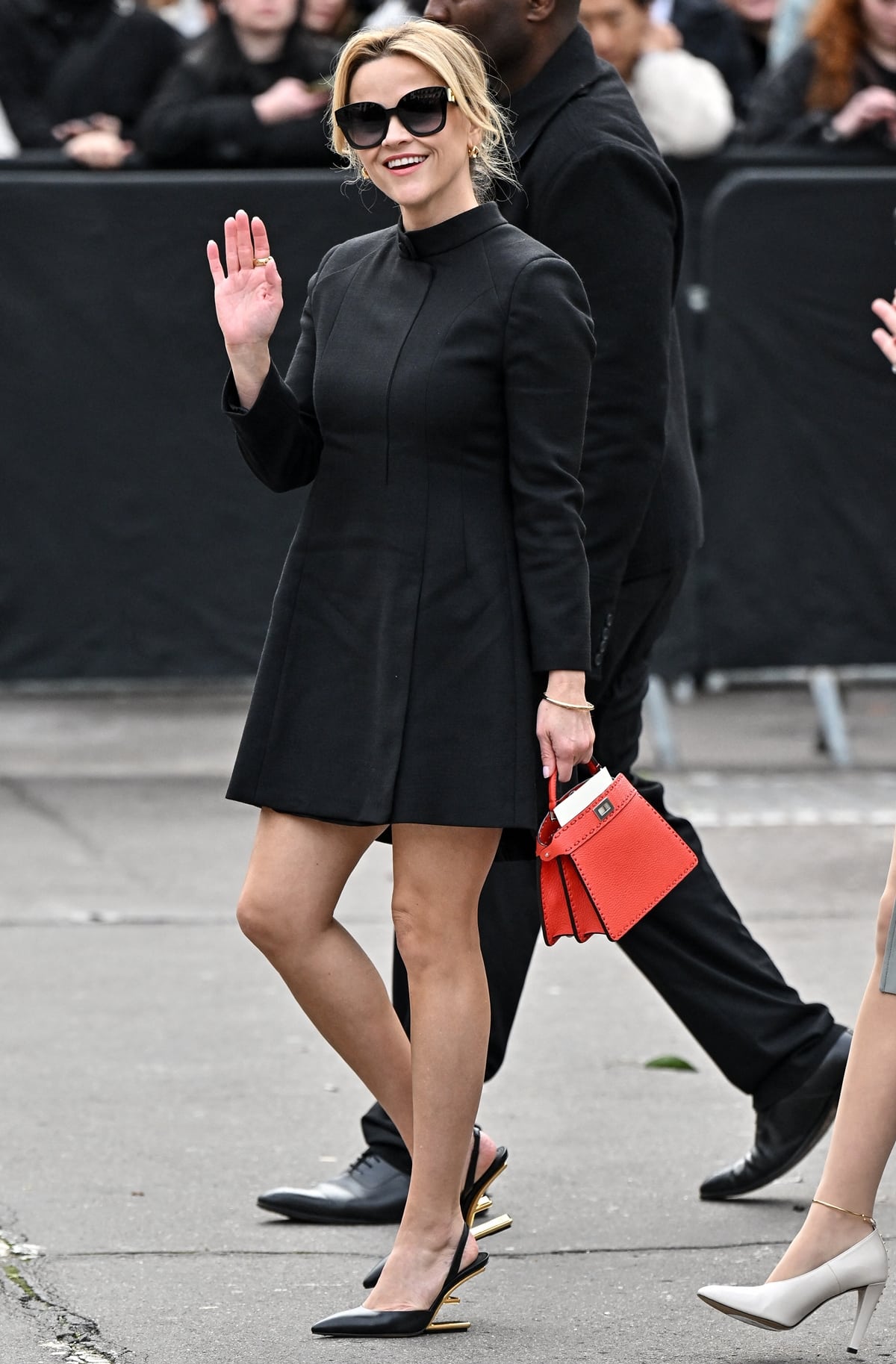 Reese Witherspoon exudes timeless elegance in a sophisticated Fendi black wool dress, complemented by black Vitello leather slingback pumps with metallic gold heels, at the Fendi Haute Couture Spring/Summer 2024 show