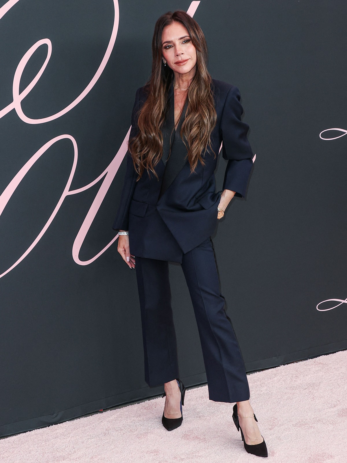 Victoria Beckham opts for understated elegance in a navy pantsuit from her eponymous collection