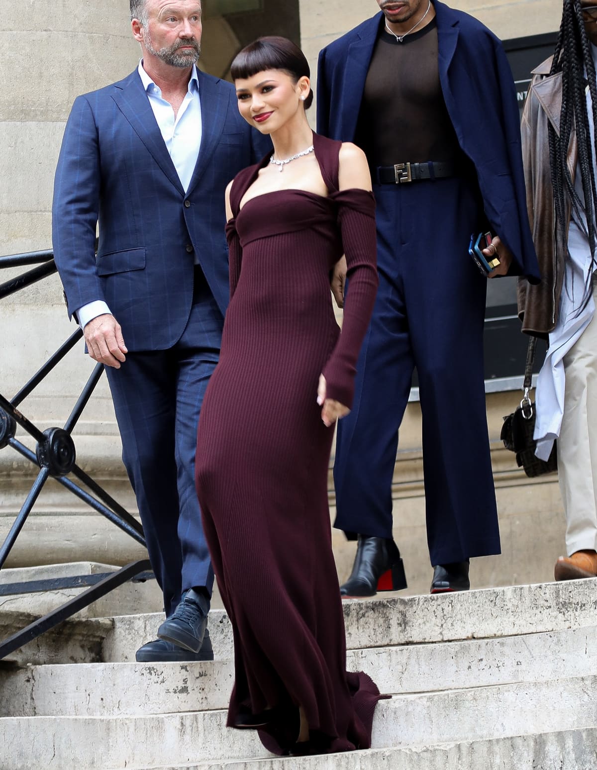 Stepping out in Fendi’s Spring-Summer 2024 Haute Couture, Zendaya turns heads in a ribbed-knit burgundy gown with distinctive harness-like detail, showcasing her versatility and fashion-forward sensibility