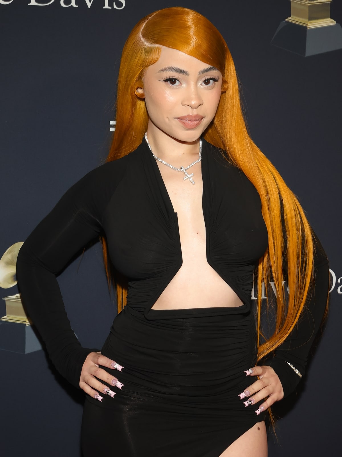 Accented with diamond jewelry and her iconic orange hair styled sleekly, Ice Spicec epitomizes glamour and confidence, staying true to her unique aesthetic