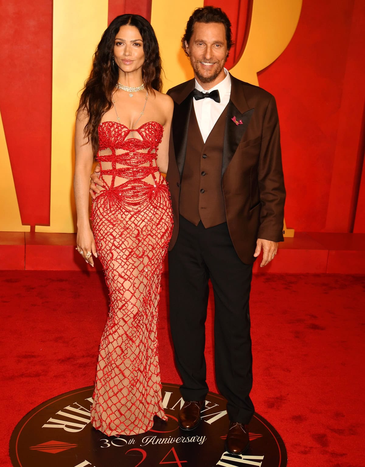 Camila Alves and Matthew McConaughey dazzle at the 2024 Vanity Fair Oscar Party, with Camila in a stunning red lace Tony Ward Couture gown