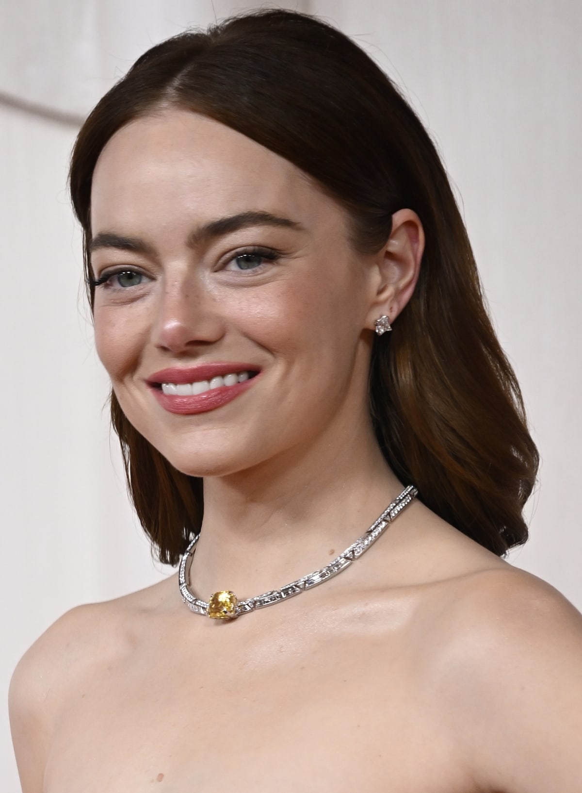 Emma Stone's elegant ensemble completed with a 30-karat white Louis Vuitton Deep Time choker necklace and natural, sophisticated makeup