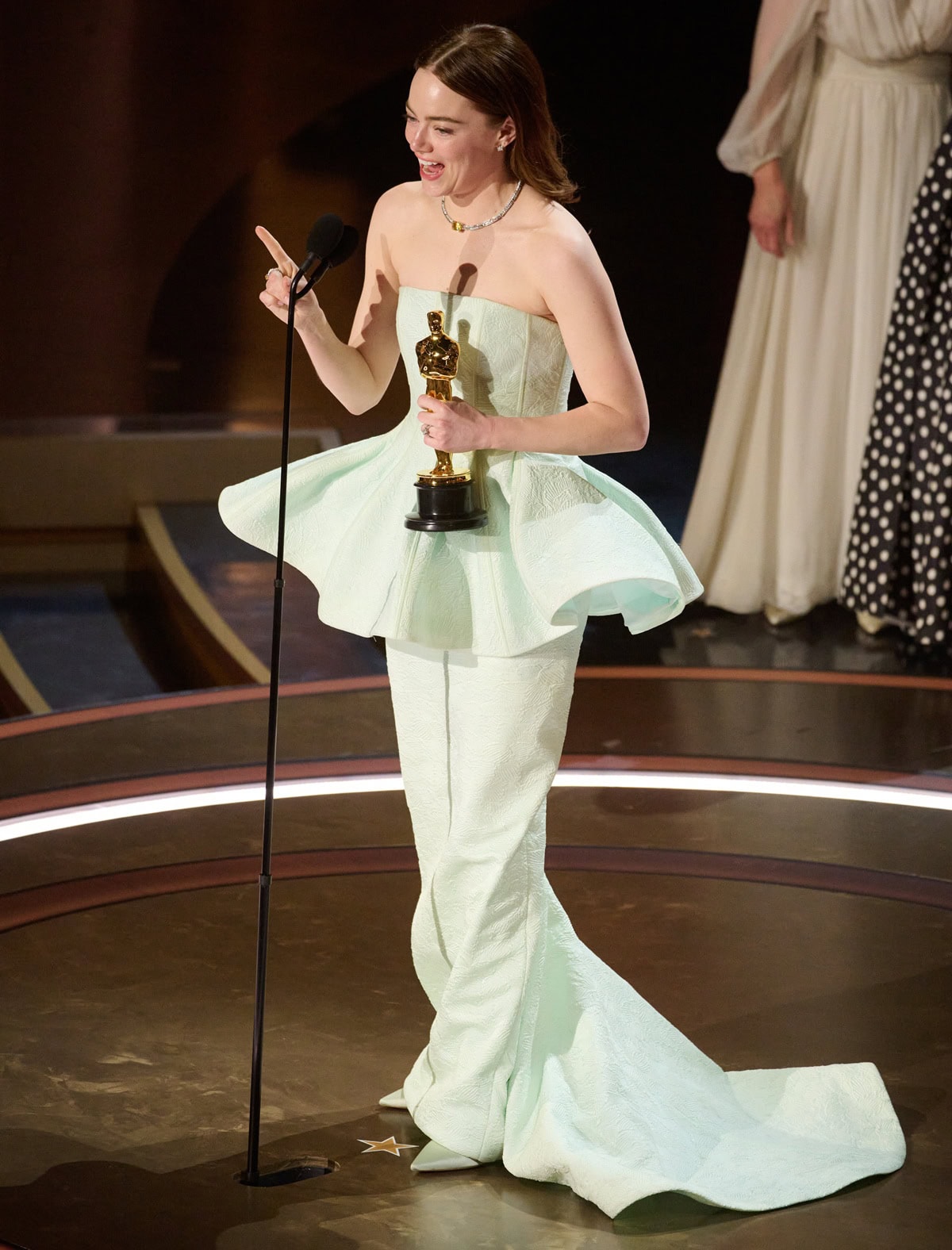 Emma Stone accepts her Oscar in mint-colored pointed-toe pumps that subtly peek out beneath her custom Louis Vuitton gown