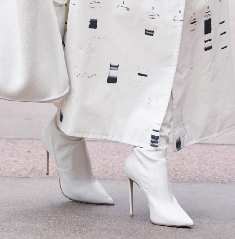Heidi Klum teams her white trench coat with milk-white stretch vegan leather thigh-high boots by Le Silla