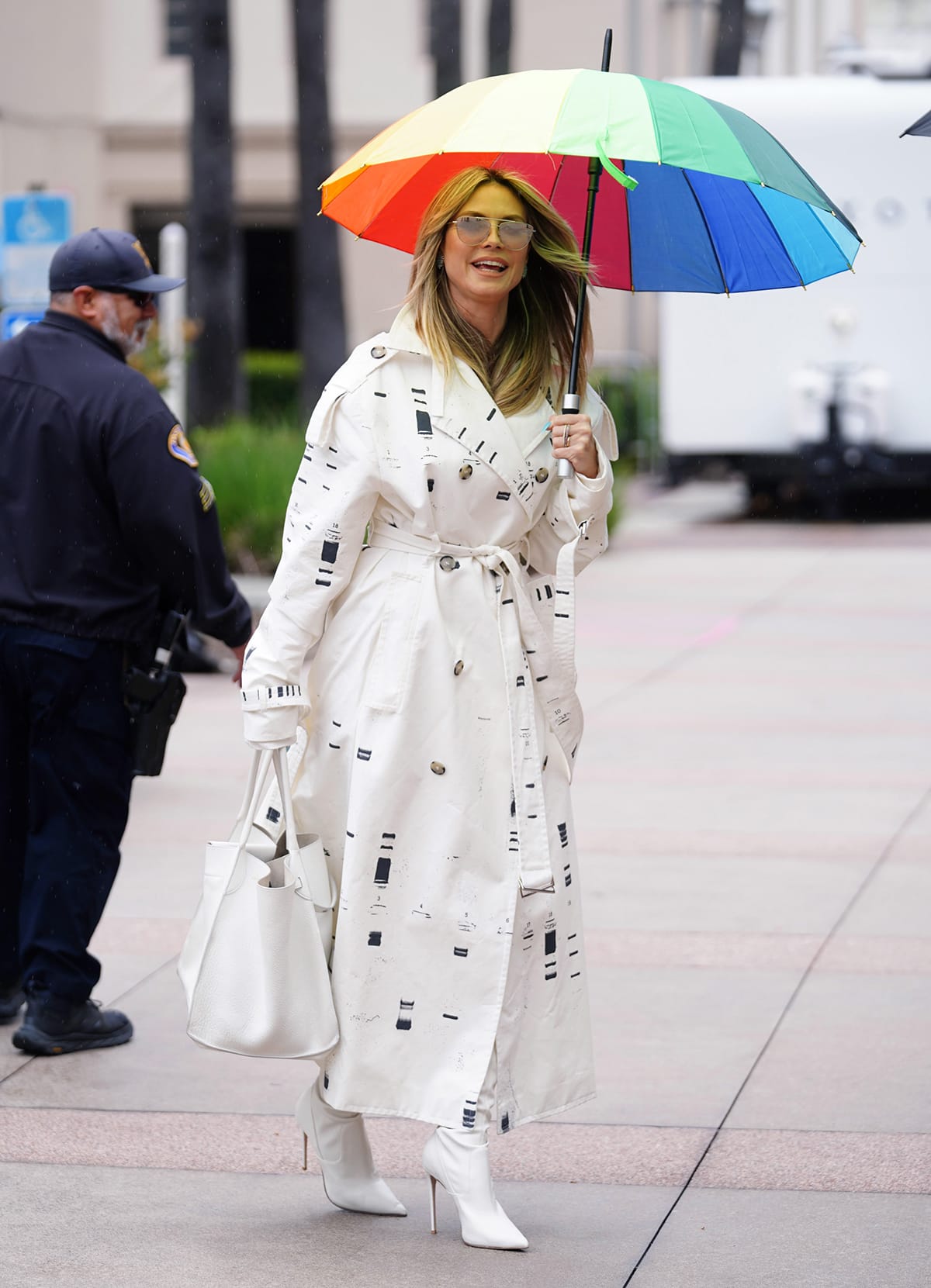 Heidi Klum embraces spring whites in a white Maison Blanche by Yannik Zamboni DNA Gel-Electrophoresis Trench Coat and white thigh-high boots outside the AGT studios on March 23, 2024