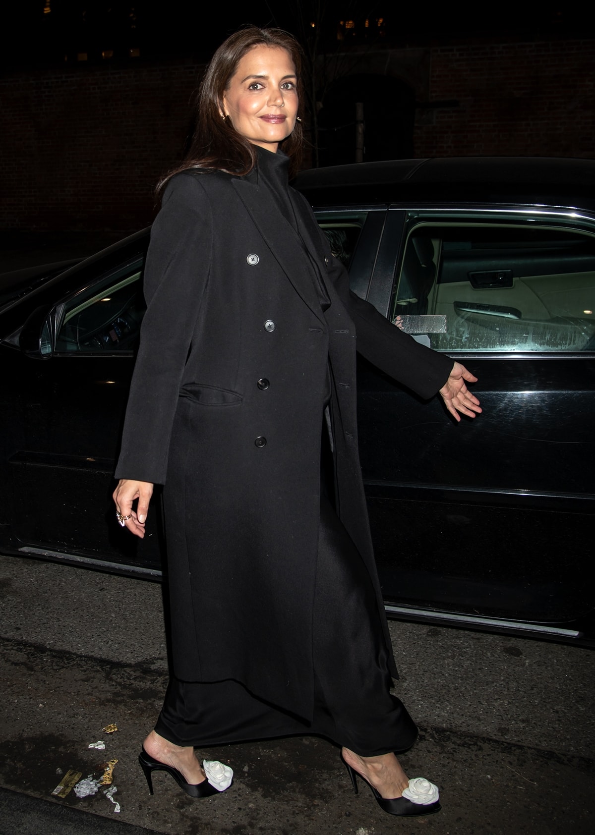 Katie Holmes makes a grand entrance draped in a striking long black double-breasted coat, exuding elegance and sophistication at the Roundabout Theatre Company’s 2024 Gala