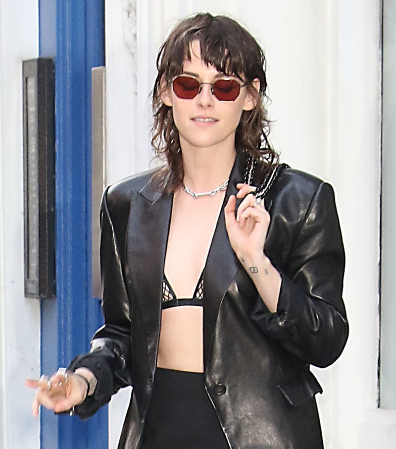 Sporting a messy mullet, Kristen Stewart adds bling to her dominatrix ensemble with a few silver rings, a chain necklace, and red sunglasses