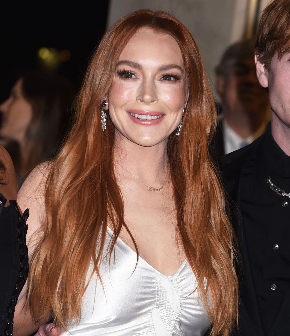 Lindsay Lohan wears her ginger hair down in waves with extensions and opts for soft pink makeup to accentuate her natural beauty