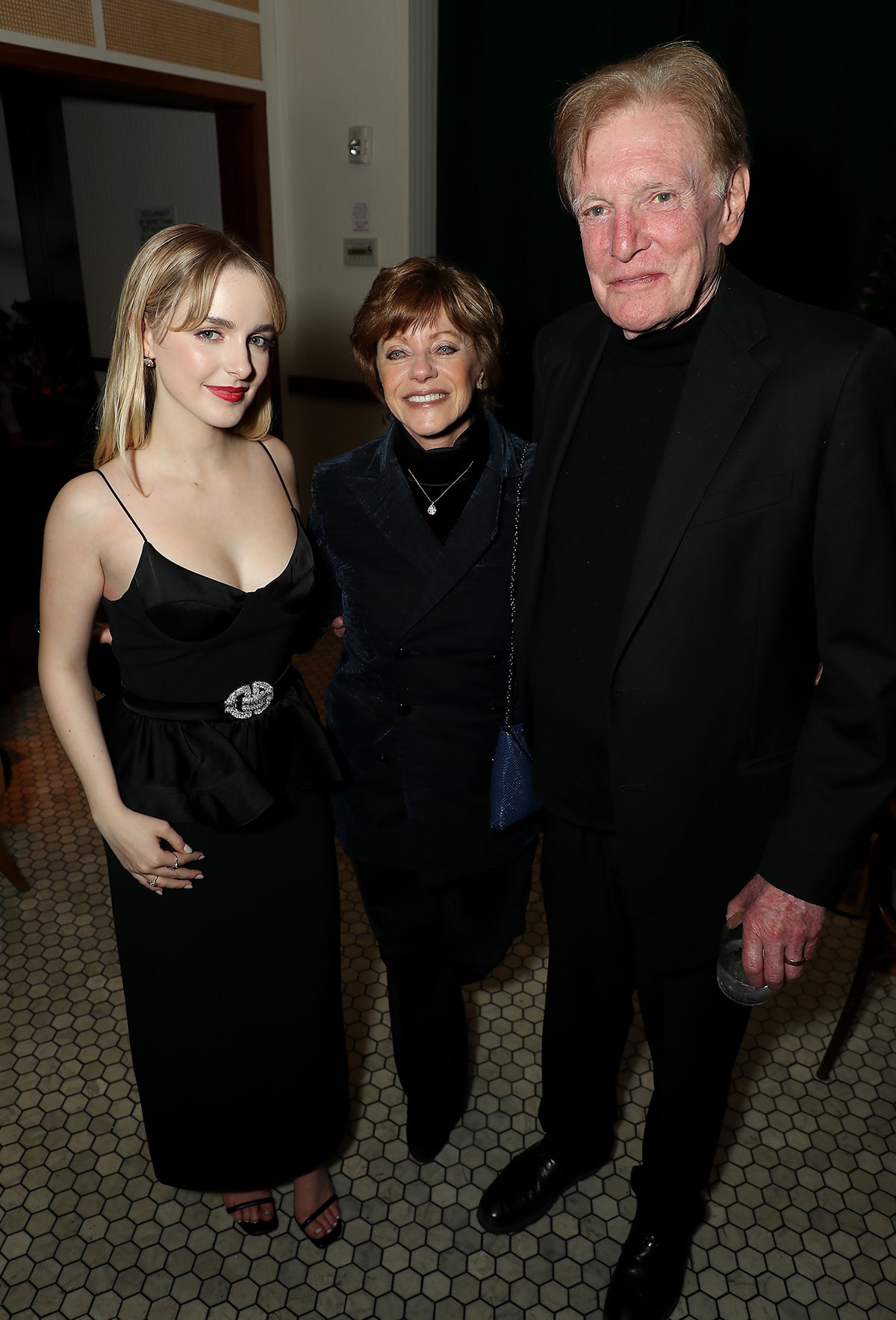 Mckenna Grace attends the Ghostbusters: Frozen Empire premiere after-party in a slinky black dress and open-toe sandals with co-star William Atherton and his wife Bobbi Goldin