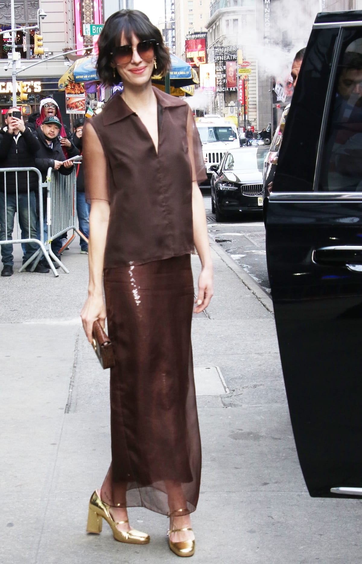 Rebecca Hall stuns in a sheer brown dress by Emilia Wickstead, showcasing a perfect balance of shimmer and transparency for a look of understated elegance