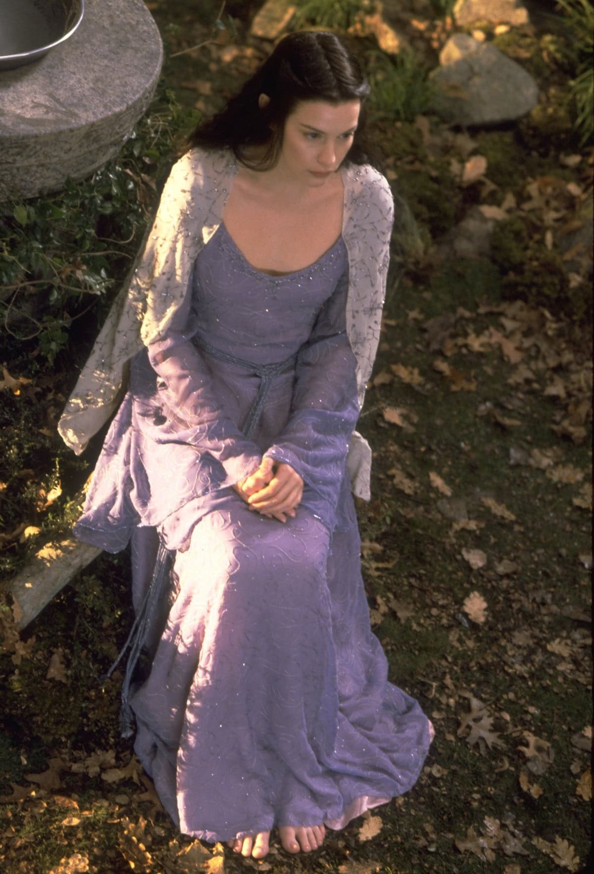 Arwen’s dreamy lavender gown, designed by Ngila Dickson, flows ethereally over bare feet—capturing the timeless, grounded elegance of Elven royalty