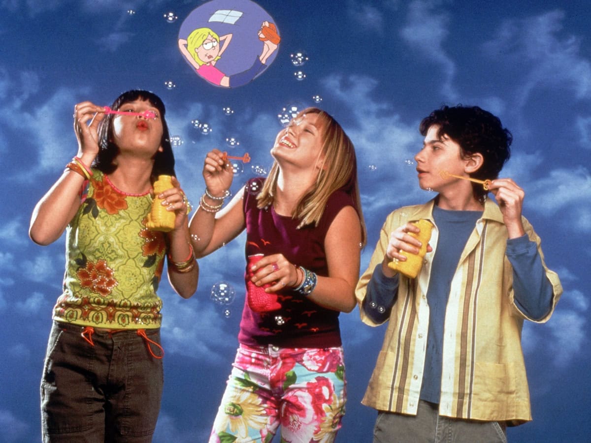Lalaine as Miranda, Hilary Duff as Lizzie, and Adam Lamberg as Gordo, the beloved trio from "Lizzie McGuire," enjoying a lighthearted bubble-blowing moment