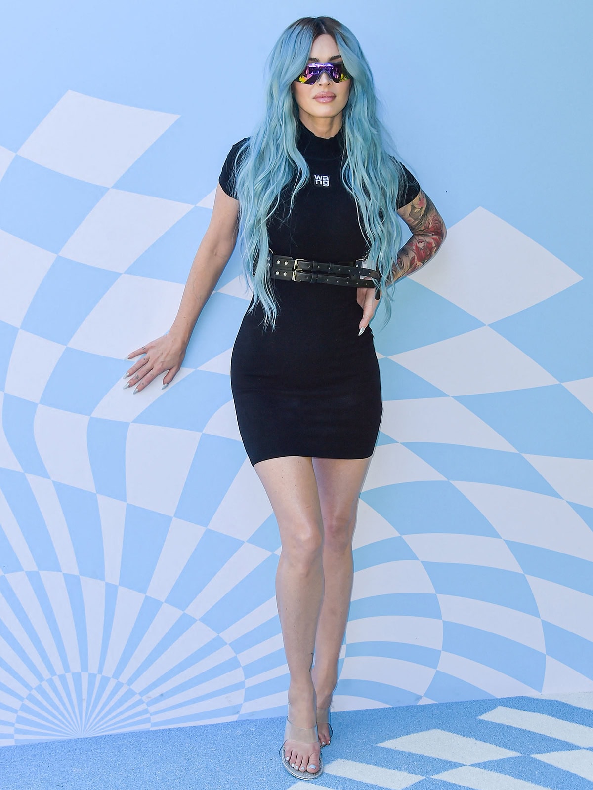 Megan Fox debuts blue hair in a little black dress with short sleeves and a mock neck by Alexander Wang at the 7th Annual REVOLVE Festival during the 2024 Coachella Valley Music And Arts Festival Weekend 1 on April 13, 2024