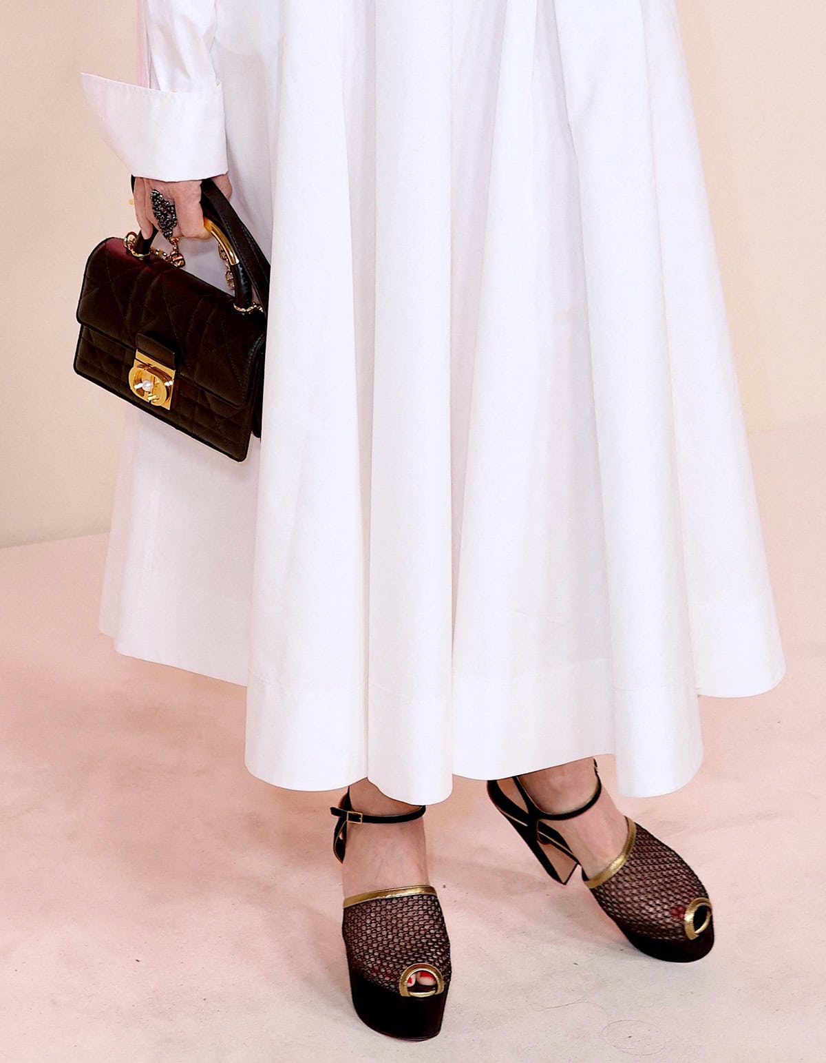 Naomi Watts teams her white dress with black-and-gold Dior peep-toe sandals with thick heels and platforms, boosting her height by several inches