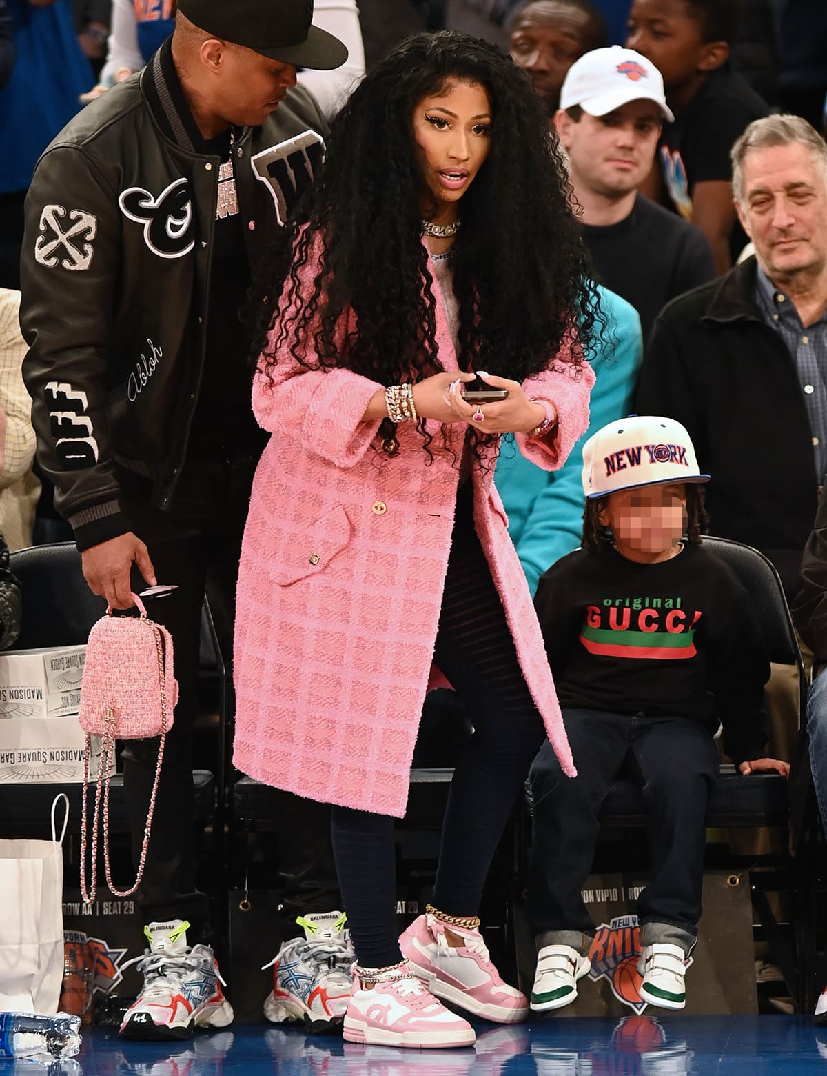 Nicki Minaj layers a pink tweed Chanel coat over her casual-chic ensemble, mixing high and low fashion