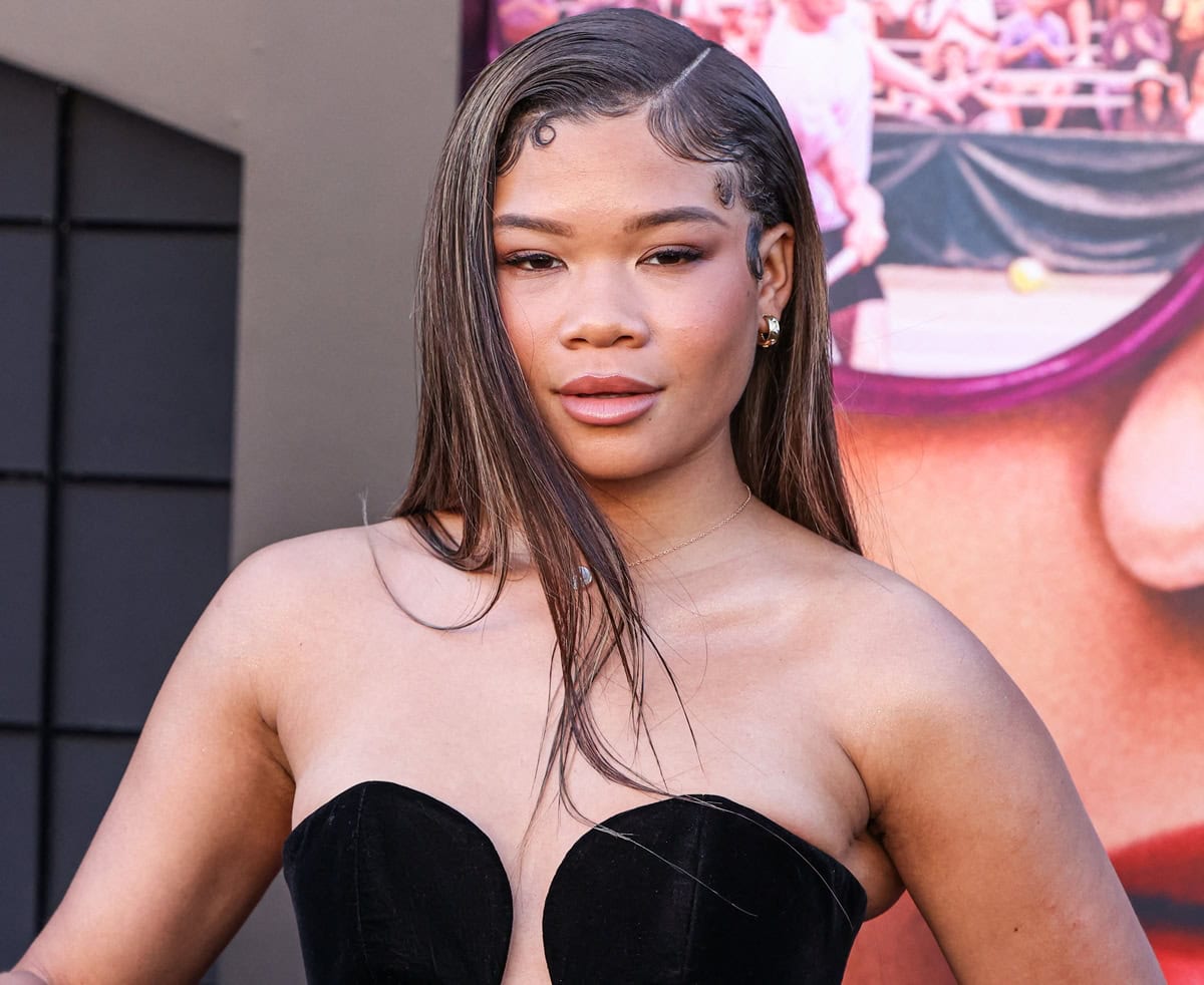 Storm Reid's hair, elegantly styled with loose strands framing her face, flowed beautifully, enhancing her sophisticated makeup palette of dark mascara, bronzy cheeks, and nude lips