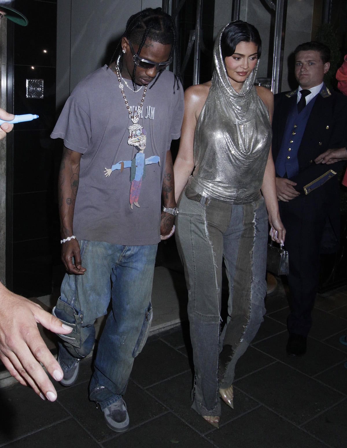 Elevated by her heels, Kylie Jenner stands nearly as tall as Travis Scott, the couple's height difference nearly vanishing as they step out in London