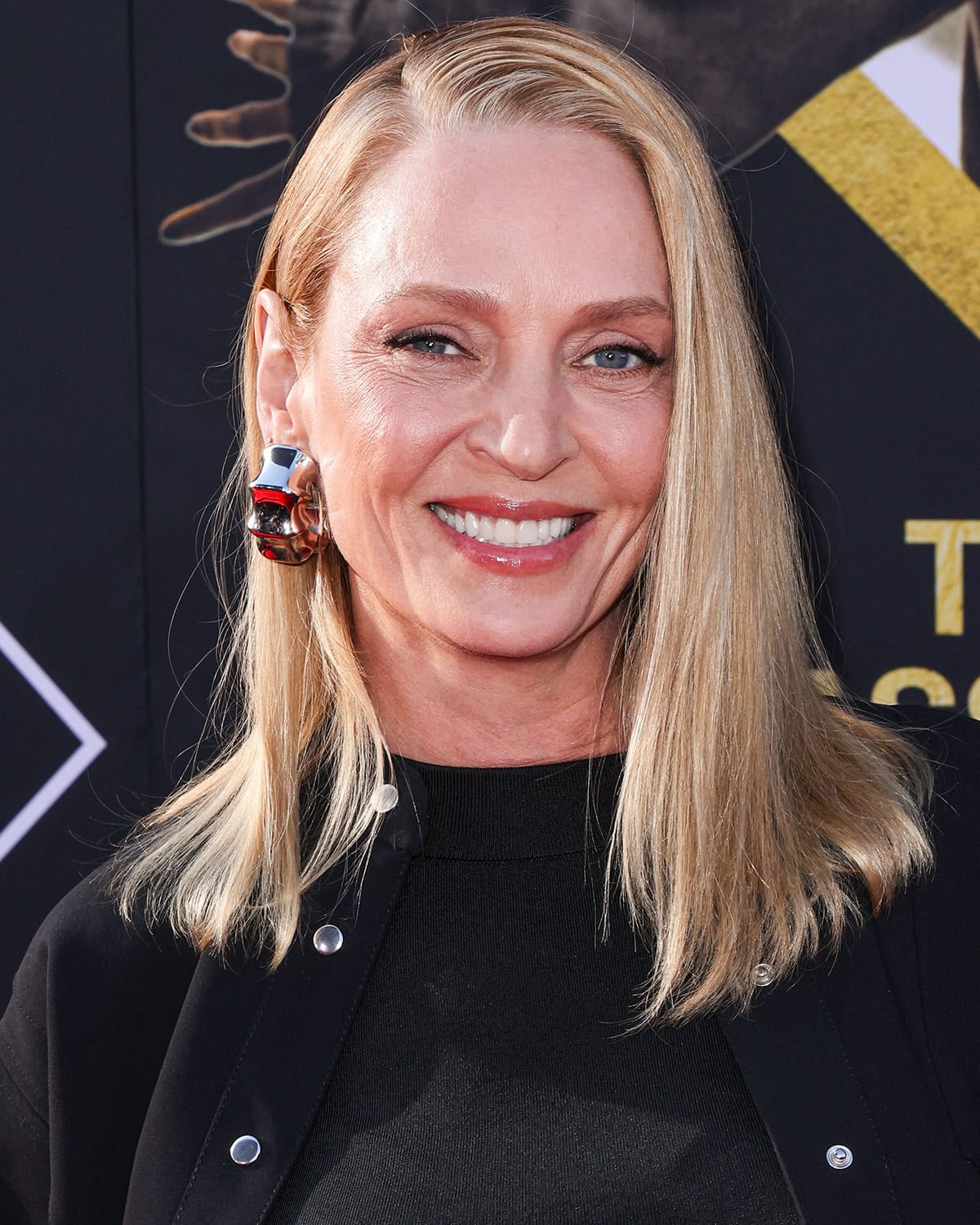 Uma Thurman displays her innate beauty with soft pink makeup and a straight, side-parted hairstyle