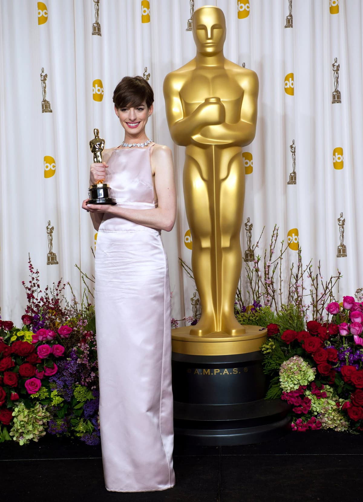 Anne Hathaway stuns in a pale pink Prada gown while holding her Oscar for Best Supporting Actress backstage at the 85th Academy Awards, held at the Dolby Theatre in Hollywood on February 24, 2013