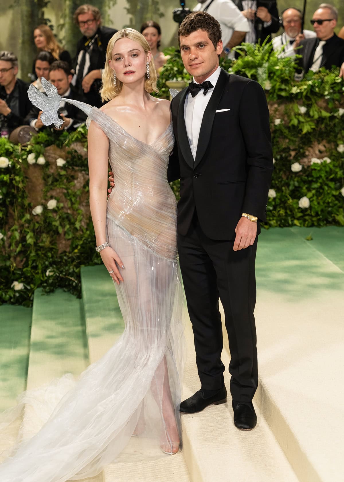 Elle Fanning, accompanied by boyfriend Gus Wenner, shines on the red carpet, her frosty-themed gown contrasting beautifully with his classic black suit
